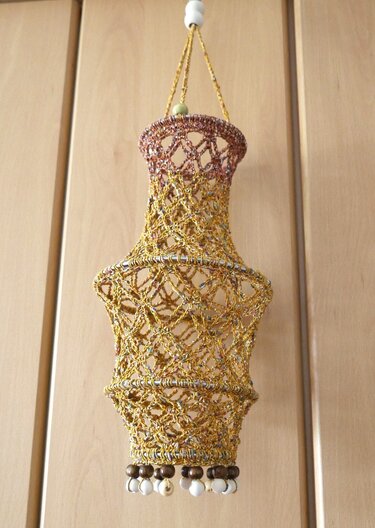 Gehäkelte goldfarbene Laterne mit Perlen am unteren Rand, hängend