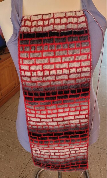 Schmaler Loop mit grafischem Ziegelmuster und Farbverlauf in Rot, Grau, Schwarz und Weiß