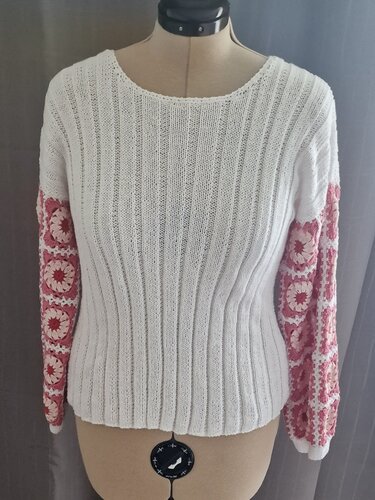 Weißer gestrickter Pullover mit rosé-weißen Granny-Ärmeln auf Schneiderpuppe