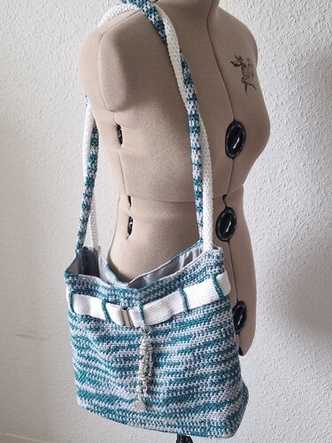 Gehäkelte türkis-weiße Shopper-Tasche mit langem Träger an einer Schneiderpuppe