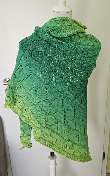 Gestricktes Dreieckstuch in Grüntönen mit diamantförmigem Lochmuster, auf Büste drapiert