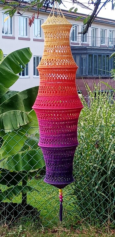 Langer gehäkelter Lampion in Gelb‑Orange‑Pink‑Lila Verlauf, hängend mit Perlen und Quaste