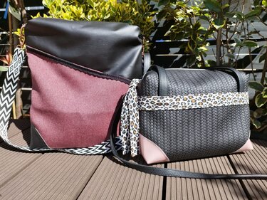Zwei selbstgenähte Taschen auf einer Holzterrasse: große Umhängetasche mit geometrischem Gurt, kleine geflochtene Schultertasche mit Leopardenmuster.