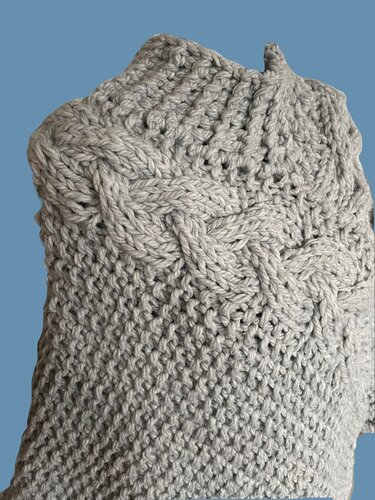 Nahaufnahme eines grauen gestrickten Damenpullovers mit Zopf- und Strukturmuster