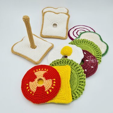 Stapelbares Häkel-Sandwich mit Toastscheiben, Häkelständer und Zutaten wie Tomate, Käse, Salat und Ei.