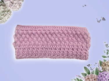 Fliederfarbenes gehäkeltes Stirnband mit reliefartiger Struktur auf hellem Hintergrund