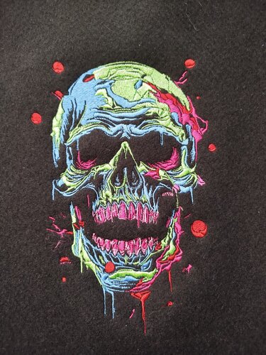 Bunte Stickerei eines schmelzenden Totenkopfs in Neonfarben auf schwarzem Stoff
