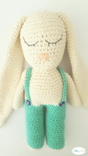 Gehäkelter cremefarbener Amigurumi‑Hase mit langen Ohren und mintgrüner Latzhose