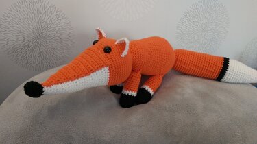 Gehäkelter orange-weißer Fuchs Amigurumi mit langer Schnauze und schwarzen Pfoten