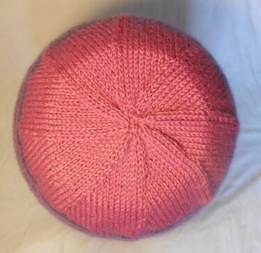Oberseite einer gestrickten Mütze mit Sternabnahme, rosa Garn