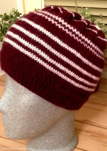 Weinrote Strickmütze mit weißen Querstreifen auf Styroporkopf