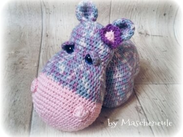 Gehäkeltes Amigurumi-Nilpferd aus pastellfarbenem Garn mit rosa Schnauze und Schleife