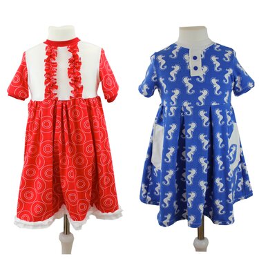 Zwei Kinderkleider auf Schneiderpuppen: links rotes Kleid mit kreisförmigem Muster und Rüschen, rechts blaues Kleid mit Seepferdchenmuster und Taschen