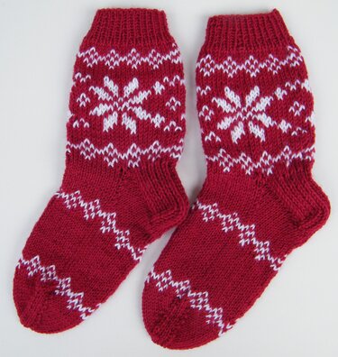 Paar rot-weiße Norwegerstrick-Socken mit Schneeflockenmotiv
