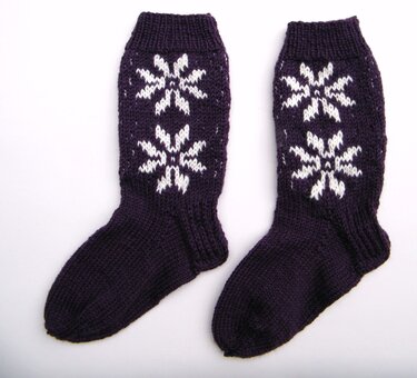 Dunkelviolette Stricksocken mit weißen Sternen und Rippbündchen