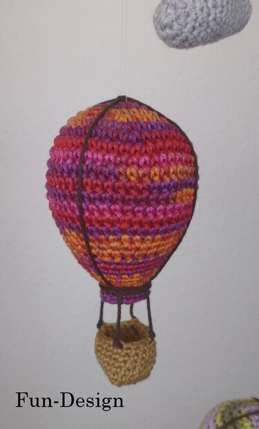 Gehäkelter Heißluftballon-Amigurumi in Pink, Orange und Lila mit Korb