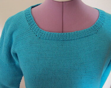 Türkiser Strickpullover auf Schneiderpuppe mit Rippbündchen am Halsausschnitt