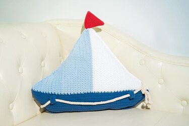 Gehäkeltes Segelboot-Kissen blau-weiß mit roter Flagge auf Sofa