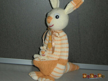 Gestricktes gestreiftes Beuteltier mit kleinem Kuscheltier im Beutel