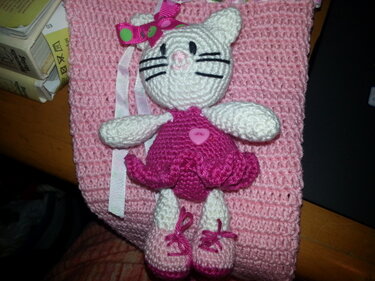Gehäkelte weiße Amigurumi-Katze mit rosa Kleid, Schleife und Schuhen