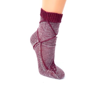 Nahaufnahme einer gestrickten Socke mit Rippbündchen und diagonalen Ziernähten