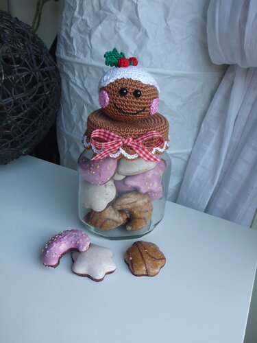 Glas mit Weihnachtskeksen und gehäkeltem Lebkuchen-Deckel mit roter Schleife