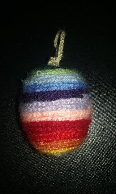Gehäkeltes Osterei mit bunten horizontalen Streifen und Aufhängeschlaufe