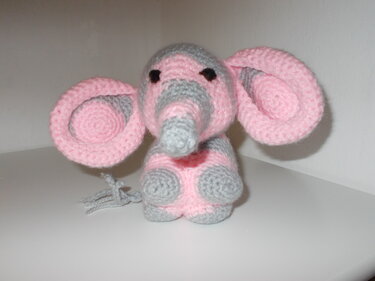 Handgehäkelter Amigurumi‑Elefant in Rosa und Grau mit großen Ohren auf weißem Hintergrund