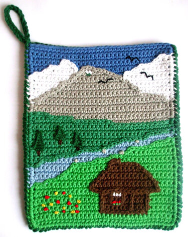 Quadratischer gehäkelter Topflappen mit Berg-, Fluss- und Häuschenmotiv und grüner Aufhängeschlaufe