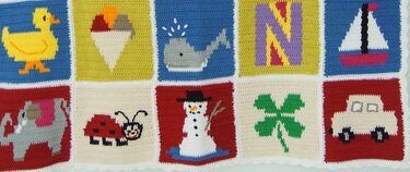 Gehäkelte Granny-Squares mit applizierten Kindermotiven: Ente, Eistüte, Wal, Buchstabe N, Segelboot, Elefant, Marienkäfer, Schneemann, Kleeblatt und Auto, verbunden durch weiße Umrandung