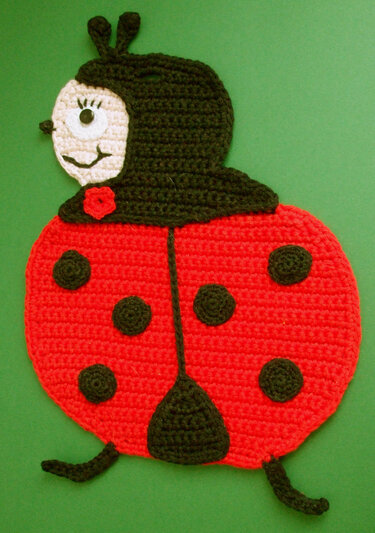 Gehäkelter Marienkäfer-Topflappen in Rot mit schwarzen Punkten und Gesicht, ideal für Küche und Deko