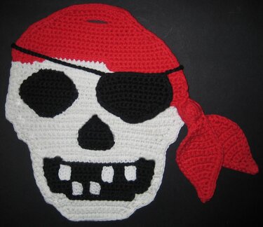 Gehäkelter Piraten-Totenkopf in Weiß, Schwarz und Rot mit Augenklappe und rotem Bandana.