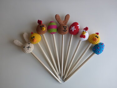 Fächerförmig angeordnete gehäkelte Oster-Topper (Hasen, Küken, Eier) auf Holzbleistiften