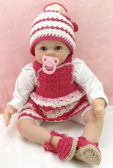 Babypuppe mit gehäkelter, pink-weiß gestreifter Babymütze, Kleidchen und Schühchen