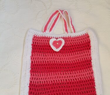 Gehäkelte Tasche in Pink- und Weißtönen mit Herzapplikation