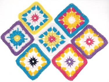 Sieben bunte gehäkelte Granny Squares mit Stern- und Blütenmustern auf weißem Hintergrund.