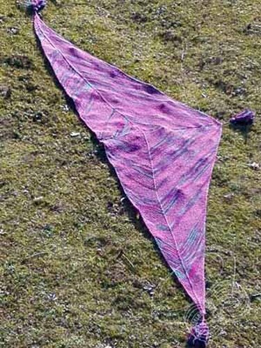 Gestricktes Dreieckstuch in Lila- und Türkistönen auf Gras