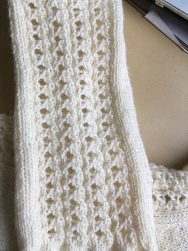 Cremeweiße gestrickte Beinstulpe mit Ajourmuster und Rippenkante