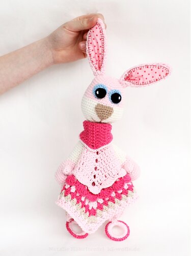 Rosafarbener gehäkelter Amigurumi-Hase mit Spitzenkleid und gefütterten Ohren