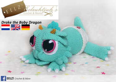 Gehäkelter mintfarbener Baby-Drache Amigurumi mit großen rosa-umrandeten Augen, Hörnern und Schuppen, liegend