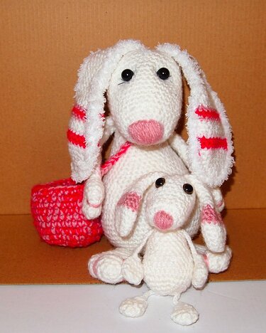 Großer und kleiner gehäkelter Hase in Weiß mit rosa Details und kleinem Korb.