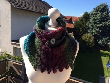 Gestrickter Loop mit Farbverlauf von Türkis bis Rot, Knopfverschluss und gezacktem Rand auf Schneiderpuppe