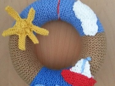 Gestrickter Kranz mit Sonne, Wolke und Segelboot