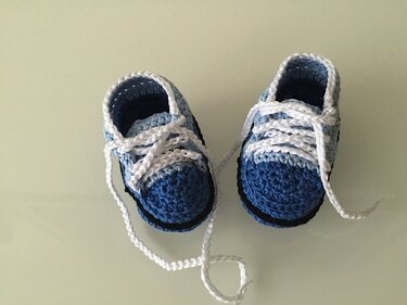 Gehäkelte Babyschuhe in Blau und Weiß im Sneaker-Stil mit weißen Schnürbändern
