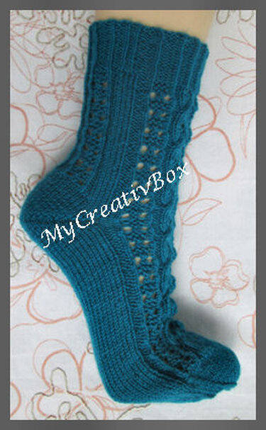 Petrolfarbene gestrickte Socke mit Zopf- und Lochmuster auf hellem Untergrund.