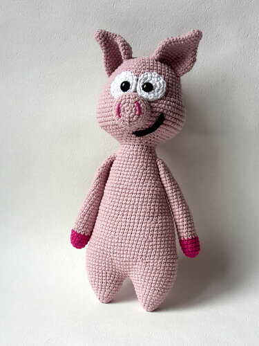 Rosa Amigurumi-Schwein mit weißen Augen, schwarzem Mund und pinken Hufen, gehäkelt vor hellem Hintergrund.