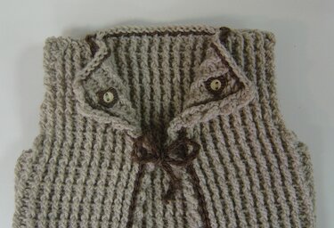 Gehäkelte beige Babyweste mit Rippenmuster, Knöpfen und brauner Schleife