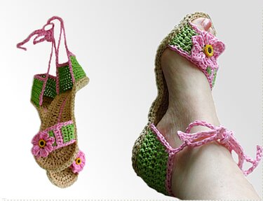 Zwei handgehäkelte Damen-Ballerinas in Grün und Rosa mit Blumenapplikationen; eine getragen, eine hängend