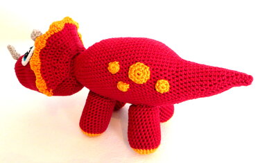 Rotes gehäkeltes Triceratops-Amigurumi mit gelber Halskrause und Punkten
