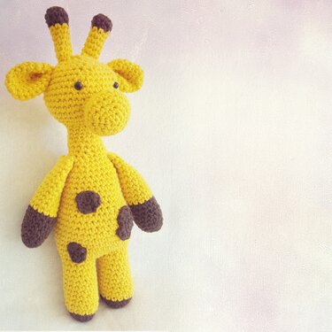 Gehäkelte gelbe Amigurumi-Giraffe mit braunen Flecken